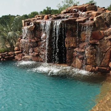 Lagoon style swimming pool with waterfall grotto with spa inside.