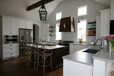 Inspiration for a mid-sized eclectic u-shaped medium tone wood floor open concept kitchen remodel in Detroit with an undermount sink, flat-panel cabinets, white cabinets, quartz countertops, gray backsplash, stone tile backsplash, stainless steel appliances and an island