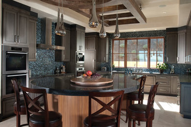 Mid-sized tuscan u-shaped ceramic tile eat-in kitchen photo in San Francisco with a drop-in sink, recessed-panel cabinets, medium tone wood cabinets, marble countertops, multicolored backsplash, mosaic tile backsplash, stainless steel appliances and an island