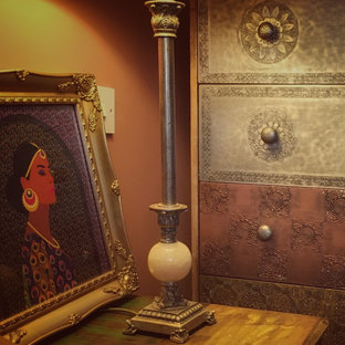 Idee per una camera matrimoniale etnica di medie dimensioni con pareti arancioni, pavimento in laminato, nessun camino e pavimento marrone