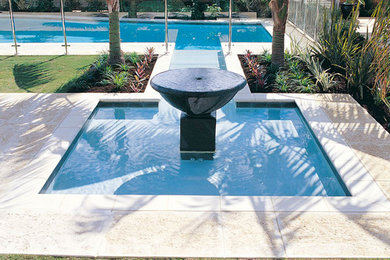 Inspiration for a large modern backyard custom-shaped pool in Perth with a hot tub and natural stone pavers.