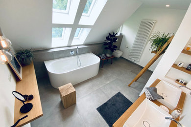 Großes Modernes Badezimmer mit weißen Schränken, freistehender Badewanne, offener Dusche, Wandtoilette, weißer Wandfarbe, Betonboden, Aufsatzwaschbecken, grauem Boden, offener Dusche, Doppelwaschbecken und schwebendem Waschtisch in Sonstige