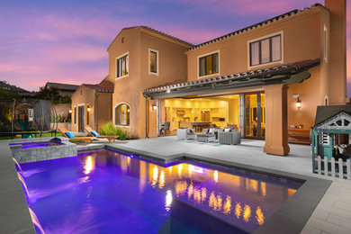 Large backyard concrete paver and rectangular natural pool landscaping photo in Salt Lake City