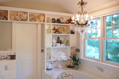 Alcove shower - mid-sized traditional master white tile and marble tile marble floor and white floor alcove shower idea in New York with furniture-like cabinets, white cabinets, an undermount tub, a one-piece toilet, gray walls, a drop-in sink, marble countertops and a hinged shower door