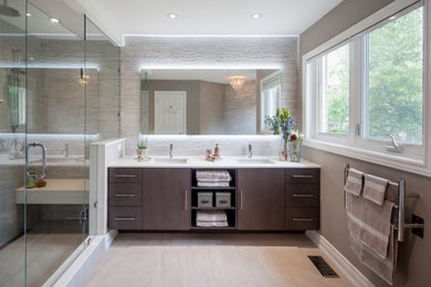 Bathroom - large master porcelain tile and double-sink bathroom idea in Toronto with flat-panel cabinets, a two-piece toilet, an undermount sink, a hinged shower door, white countertops and a built-in vanity
