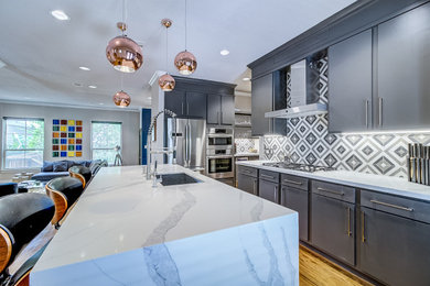Kitchen - mediterranean light wood floor and brown floor kitchen idea in Houston with an undermount sink, flat-panel cabinets, gray cabinets, quartz countertops, marble backsplash, stainless steel appliances, an island and white countertops