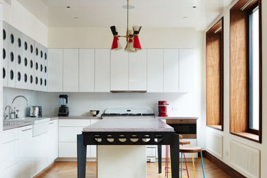 Inspiration for a mid-sized contemporary l-shaped kitchen in New York with a farmhouse sink, flat-panel cabinets, white cabinets, wood benchtops, stainless steel appliances, with island, beige floor and brown benchtop.