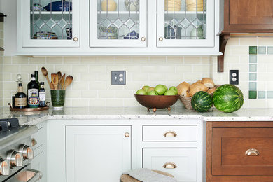 Eat-in kitchen - mid-sized farmhouse u-shaped medium tone wood floor and orange floor eat-in kitchen idea in Philadelphia with an undermount sink, shaker cabinets, blue cabinets, granite countertops, beige backsplash, subway tile backsplash, no island and white countertops