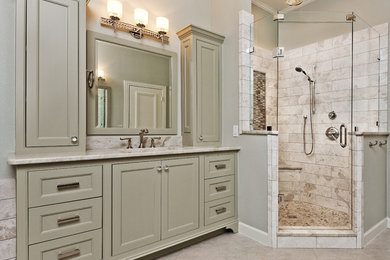 Inspiration for a traditional master bathroom in Dallas with an undermount sink, beaded inset cabinets, green cabinets, a freestanding tub, a corner shower, grey walls, porcelain floors, beige tile, stone tile and granite benchtops.