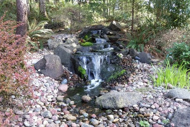 Photo of a mid-sized full sun backyard stone landscaping in Seattle.