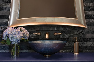 Trendy master beige tile and porcelain tile ceramic tile and gray floor corner shower photo in San Diego with flat-panel cabinets, dark wood cabinets, a two-piece toilet, beige walls, a vessel sink, granite countertops and a hinged shower door