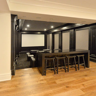 Photo of a medium sized classic enclosed home cinema in New York with black walls, carpet and a projector screen.