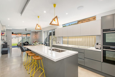 Photo of a mid-sized contemporary galley eat-in kitchen in Sydney with an undermount sink, open cabinets, grey cabinets, quartzite benchtops, stainless steel appliances, concrete floors and with island.