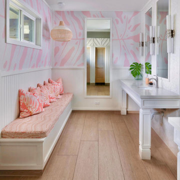 The Wāhine (women's) restroom lounge — pink monstera wallpaper, a built-in bench