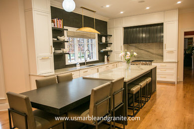 Photo of a medium sized l-shaped kitchen/diner with a submerged sink, raised-panel cabinets, white cabinets, quartz worktops, stone slab splashback, stainless steel appliances, light hardwood flooring, an island and brown floors.