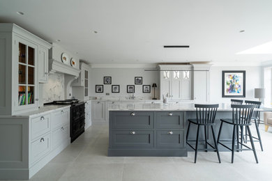 This is an example of a medium sized l-shaped kitchen/diner in Hertfordshire with a single-bowl sink, recessed-panel cabinets, grey cabinets, quartz worktops, white splashback, an island, beige floors and white worktops.