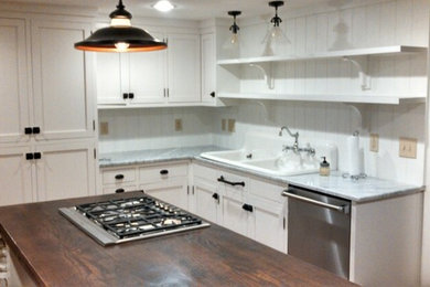 Example of a cottage l-shaped enclosed kitchen design in DC Metro with shaker cabinets, white cabinets, marble countertops, white backsplash and stainless steel appliances