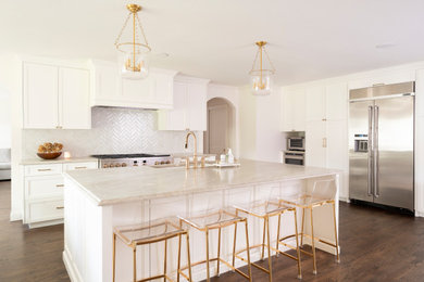 Open concept kitchen - mid-sized traditional u-shaped dark wood floor and brown floor open concept kitchen idea in Dallas with a drop-in sink, shaker cabinets, white cabinets, quartz countertops, white backsplash, stainless steel appliances, an island and beige countertops