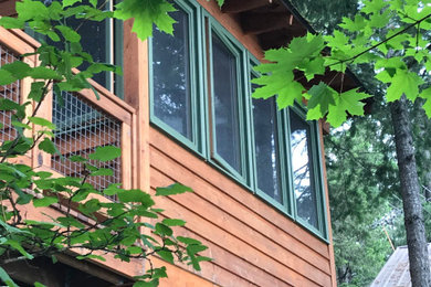 Small mountain style wood railing and screened-in side porch idea in Other with decking