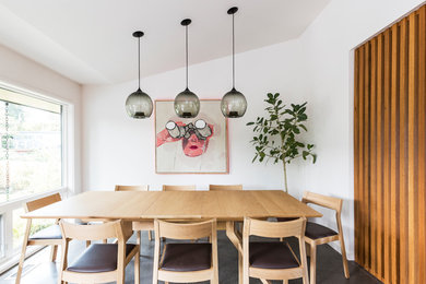 This is an example of a midcentury dining room in Seattle with white walls.