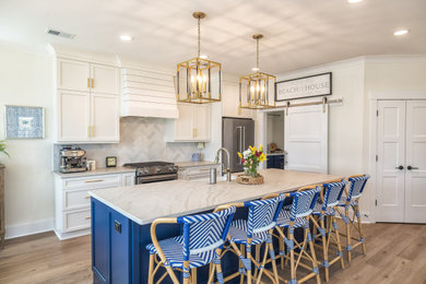 Kitchen - coastal l-shaped medium tone wood floor and brown floor kitchen idea in Other with a farmhouse sink, shaker cabinets, white cabinets, gray backsplash, stainless steel appliances, an island and gray countertops