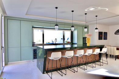 Imagen de cocina contemporánea grande abierta con fregadero bajoencimera, armarios con paneles lisos, suelo de baldosas de porcelana, una isla y encimeras verdes