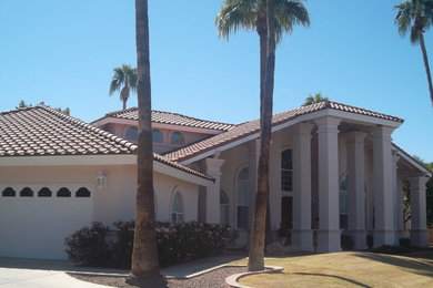 Inspiration for a huge mediterranean beige two-story stucco house exterior remodel in Phoenix with a hip roof and a tile roof