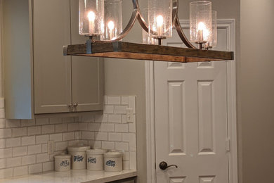 Mid-sized transitional galley medium tone wood floor and brown floor eat-in kitchen photo in Houston with shaker cabinets, gray cabinets, quartz countertops, white backsplash, subway tile backsplash, an island and white countertops