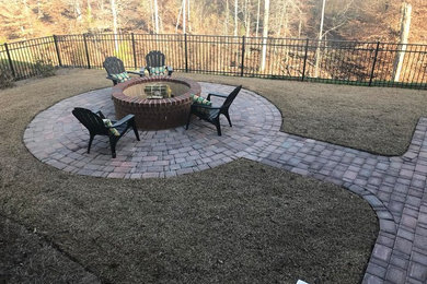 Large traditional backyard patio in Other with a fire feature and concrete pavers.