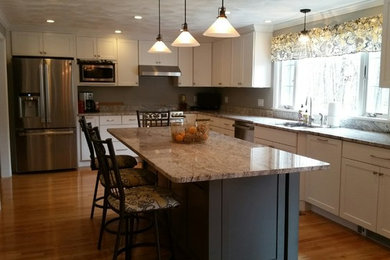 Large transitional l-shaped eat-in kitchen in Boston with an undermount sink, shaker cabinets, granite benchtops, stainless steel appliances, light hardwood floors and with island.