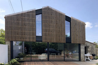 Cette photo montre une grande façade de grange rénovée tendance en bois à un étage.