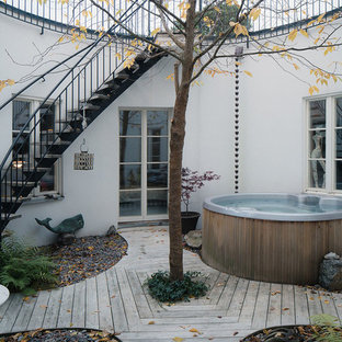 ストックホルムの中サイズの北欧スタイルのおしゃれな裏庭のデッキ (日よけなし、噴水) の写真