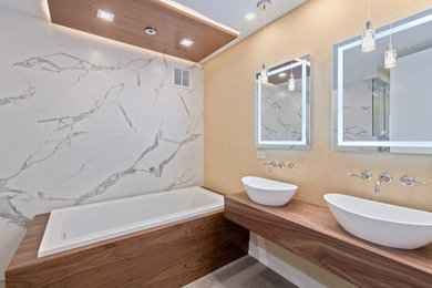 Mid-sized minimalist master white tile and stone slab porcelain tile, beige floor, double-sink, coffered ceiling and wallpaper bathroom photo in Chicago with flat-panel cabinets, brown cabinets, a one-piece toilet, yellow walls, a vessel sink, wood countertops, a hinged shower door, brown countertops and a floating vanity