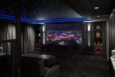 Inspiration for a mid-sized carpeted and black floor home theater remodel in Los Angeles with black walls and a projector screen