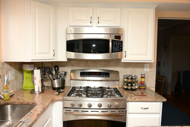 Exempel på ett modernt kök, med luckor med upphöjd panel, vita skåp, beige stänkskydd, stänkskydd i keramik, rostfria vitvaror och en köksö