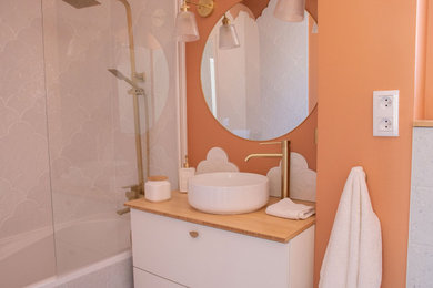 Idées déco pour une petite salle de bain moderne pour enfant avec une baignoire encastrée, WC suspendus, un carrelage blanc, des carreaux de céramique, un mur orange, un sol en terrazzo, un plan de toilette en bois, un sol gris, une fenêtre et meuble simple vasque.