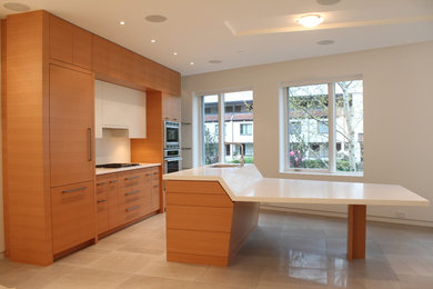 Large minimalist single-wall marble floor eat-in kitchen photo in Vancouver with a drop-in sink, flat-panel cabinets, medium tone wood cabinets, solid surface countertops, white backsplash, stone tile backsplash, stainless steel appliances and an island