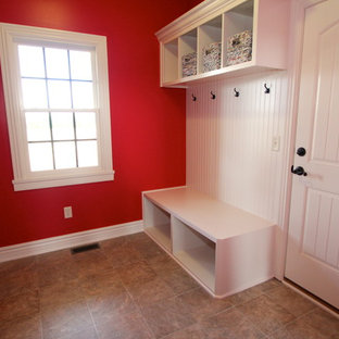 他の地域の大きい片開きドアおしゃれなマッドルーム (赤い壁、クッションフロア、白いドア) の写真