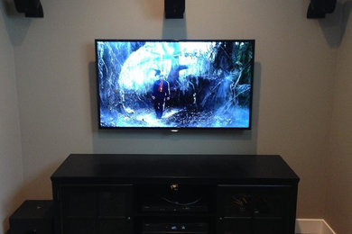 Small enclosed home theater photo in Grand Rapids with a wall-mounted tv