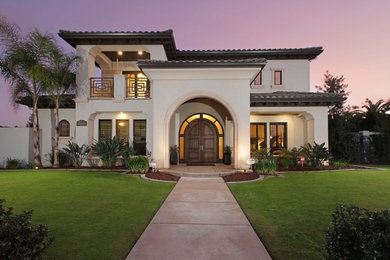 Example of a huge transitional white two-story stucco house exterior design in Other with a hip roof, a tile roof and a gray roof