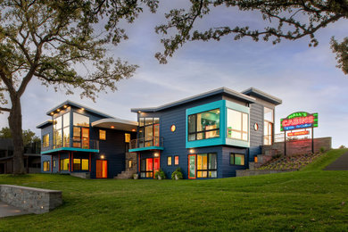 На фото: трехэтажный, синий дом в стиле фьюжн с
