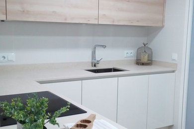 Photo of a mid-sized contemporary l-shaped separate kitchen in Other with a single-bowl sink, flat-panel cabinets, white cabinets, white splashback, light hardwood floors and no island.