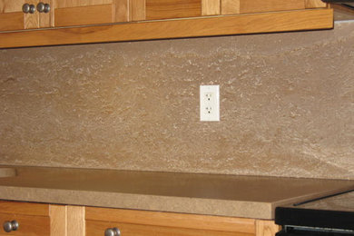 Inspiration for a mid-sized l-shaped eat-in kitchen remodel in Toronto with shaker cabinets, light wood cabinets, concrete countertops, beige backsplash and an island