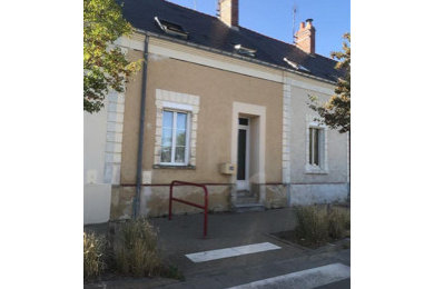 Cette photo montre une façade de maison de ville beige chic à un étage avec un toit à deux pans.