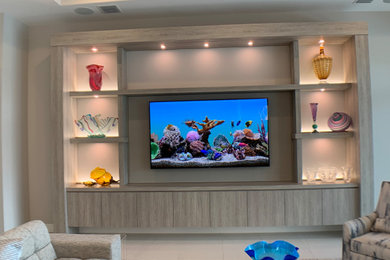 Modelo de salón abierto tradicional renovado extra grande con paredes grises, suelo de baldosas de porcelana, televisor colgado en la pared y suelo gris