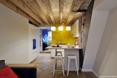 Inspiration pour une cuisine américaine encastrable design avec un évier 1 bac, un placard à porte affleurante, des portes de placard blanches, un plan de travail en bois, une crédence jaune, un sol en carrelage de céramique, un sol marron et un plan de travail beige.