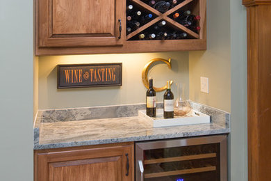 Small elegant single-wall carpeted home bar photo in Columbus with raised-panel cabinets, medium tone wood cabinets and granite countertops