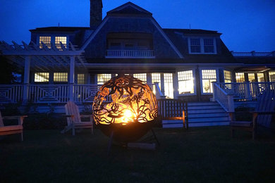 This is an example of a mid-sized contemporary backyard mulch landscaping in Boston with a fire pit.