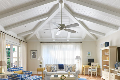 Large beach style medium tone wood floor family room photo in Miami with beige walls and a wall-mounted tv