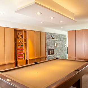 Modelo de sótano en el subsuelo moderno, grande, con paredes grises, moqueta y chimenea tradicional